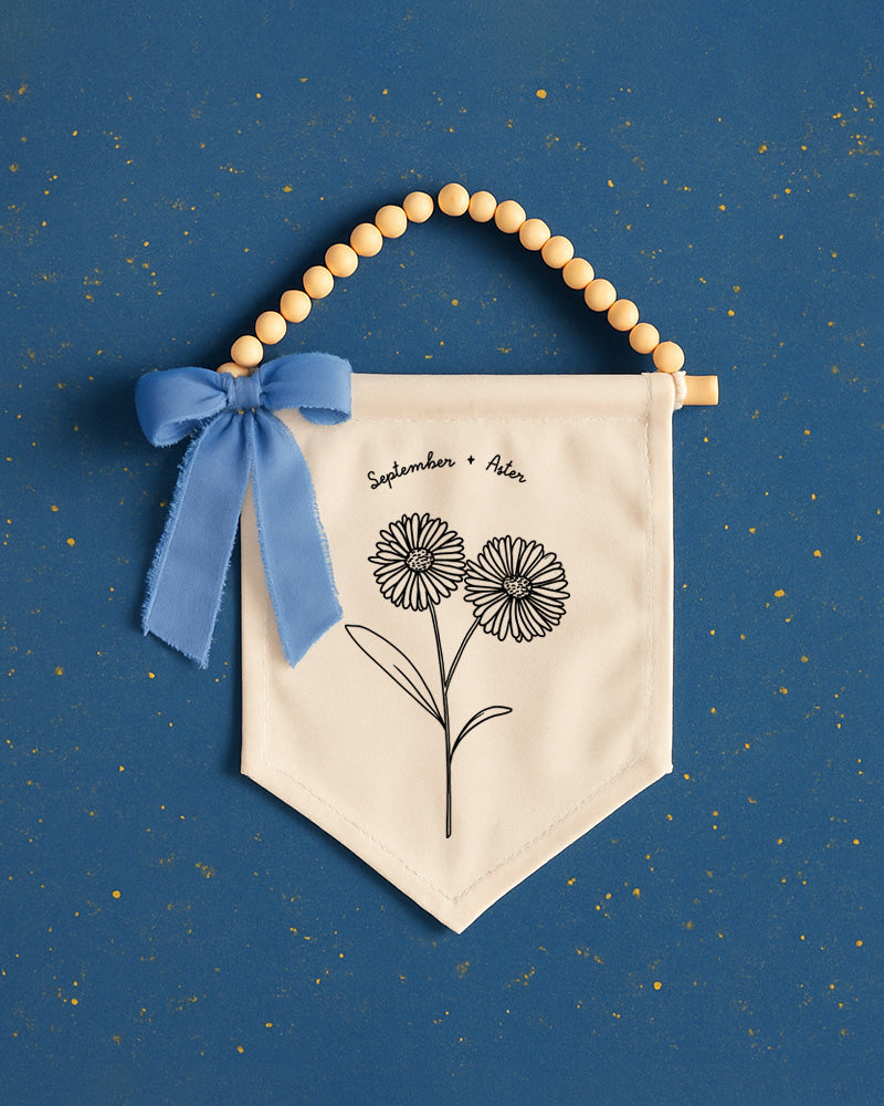 a banner with a floral design and a blue ribbon, set against a blue background with scattered gold stars.