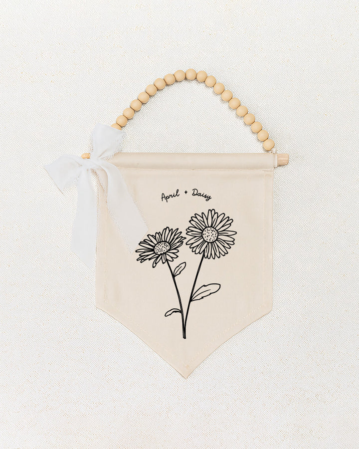 a beige banner with a floral design and a ribbon bow.