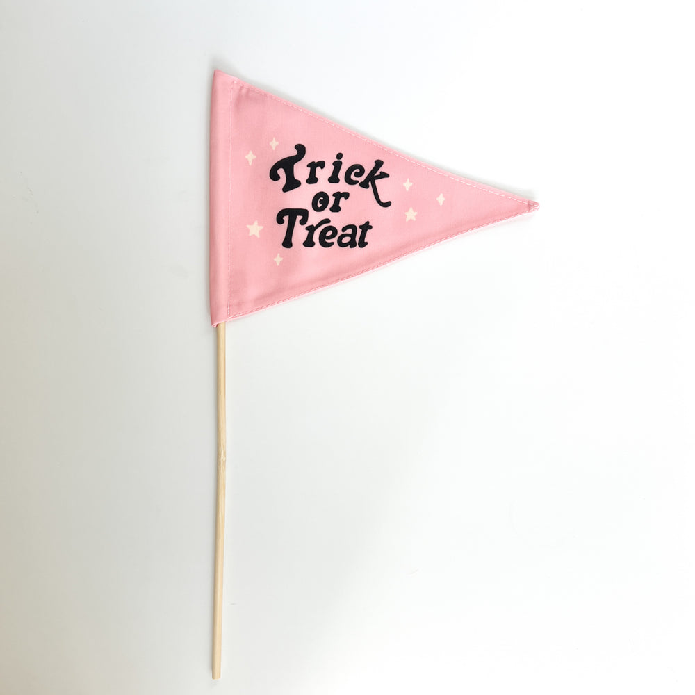 Pink triangle flag with 'Trick or Treat' text on a white background
